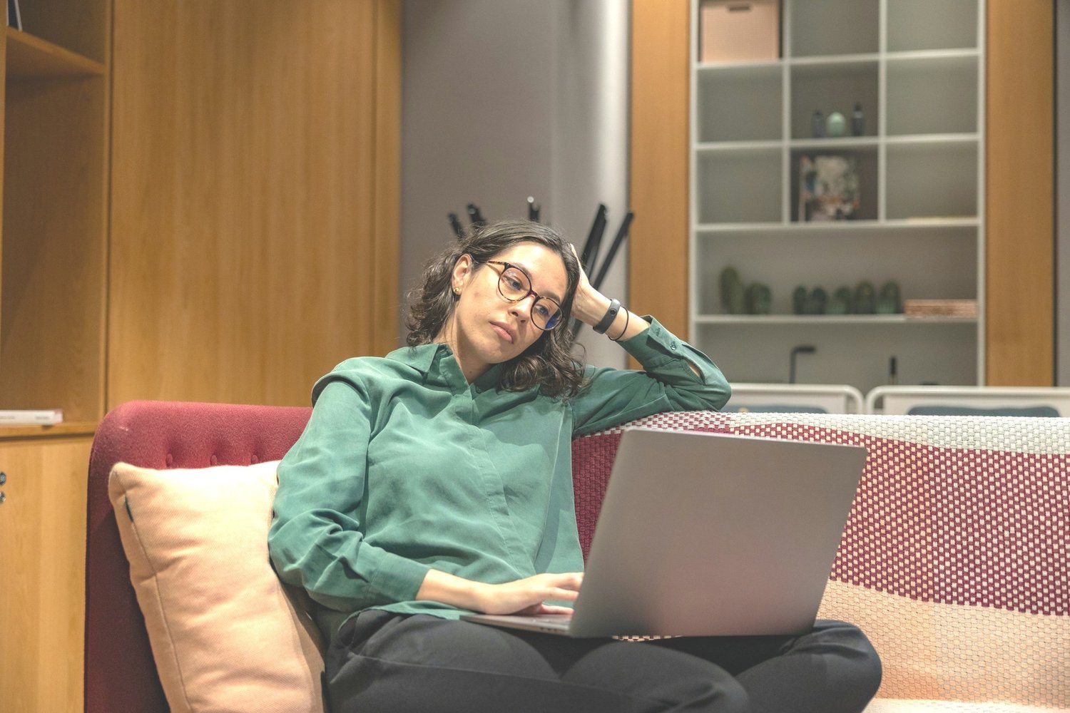 A woman in a green shirt working on her laptop